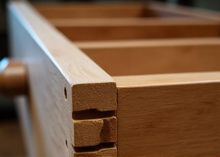Close-up of a dovetail joint on a wooden kitchen drawer.